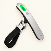 Digital ALTAIR luggage scale with a suitcase and travel accessories